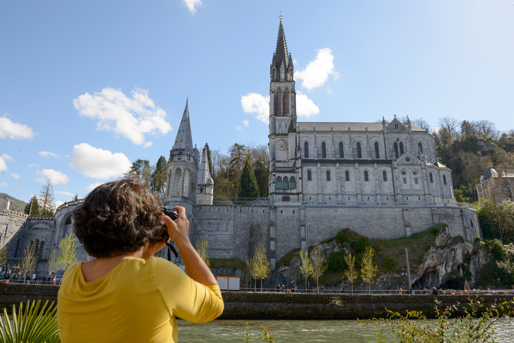 vrouw neemt foto van de basiliek van lourdes